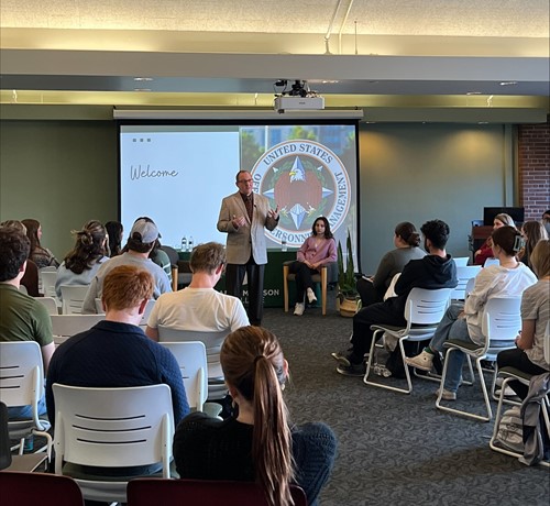 Acting Director Rob Shriver, standing, speaks with students at MSU.