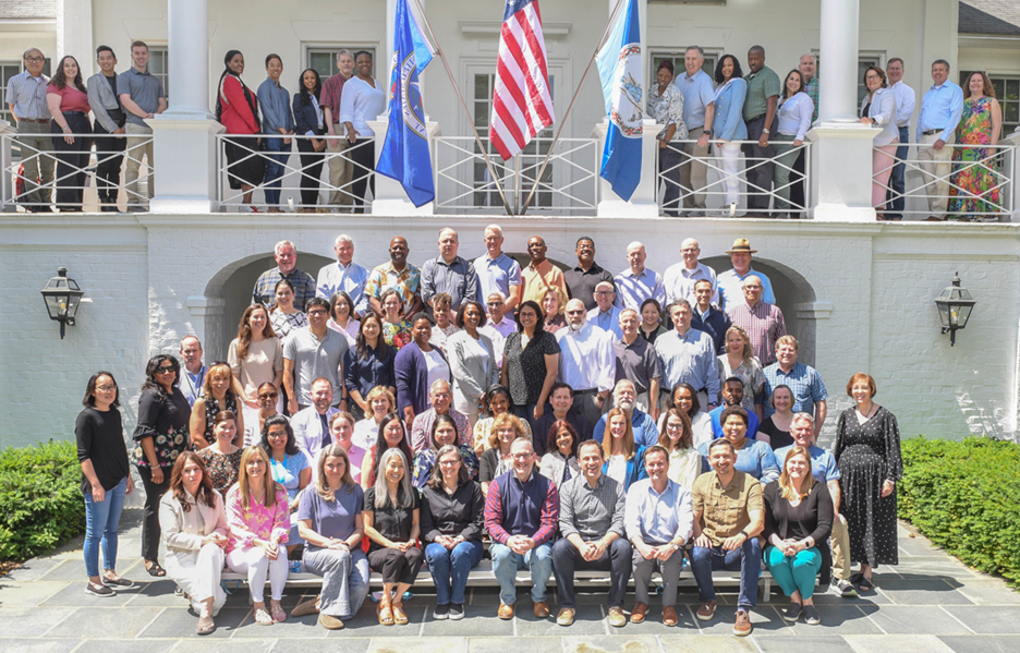 A group of individuals of OPM employees were pictured in front of the building during the 2024 Senior Leader Retreat.